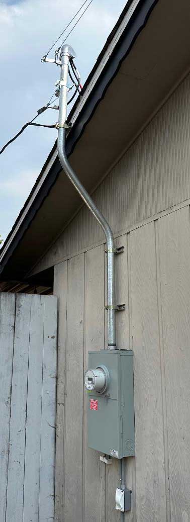 Electrical service upgrade with meter and conduit on exterior wall.